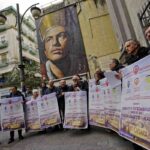 il murales di san gennaro e persone davanti con dei cartelloni