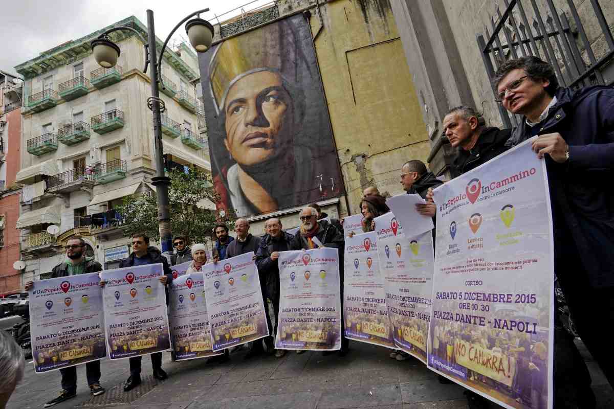 il murales di san gennaro e persone davanti con dei cartelloni