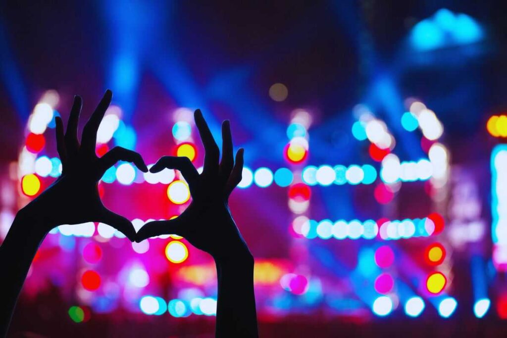 un concerto e una ragazza che fa il simbolo del cuore