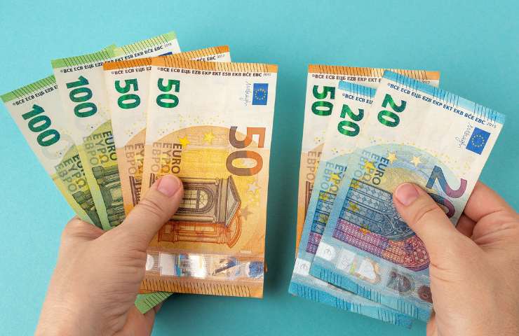 Banconote in euro di diverso taglio su sfondo azzurro