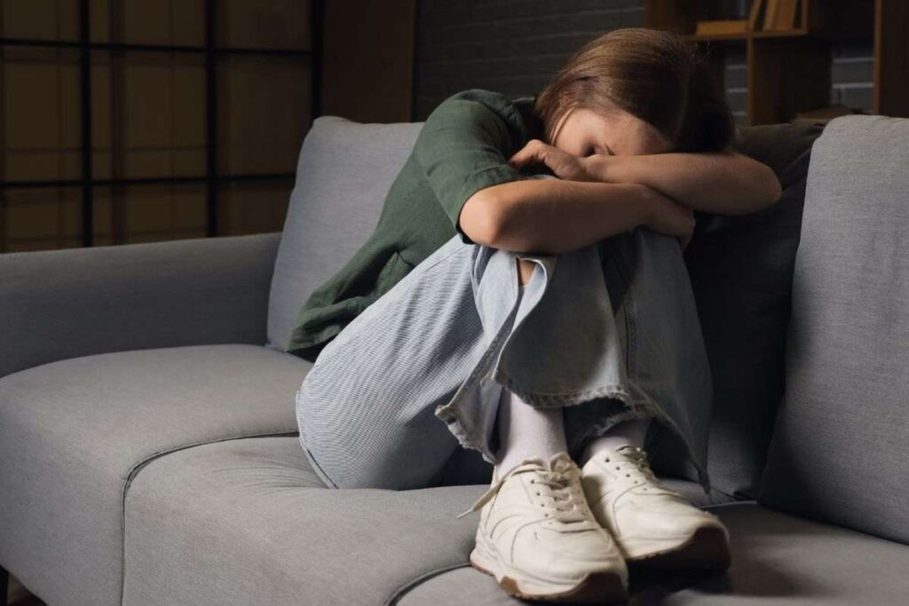 Ragazza rannicchiata sul divano