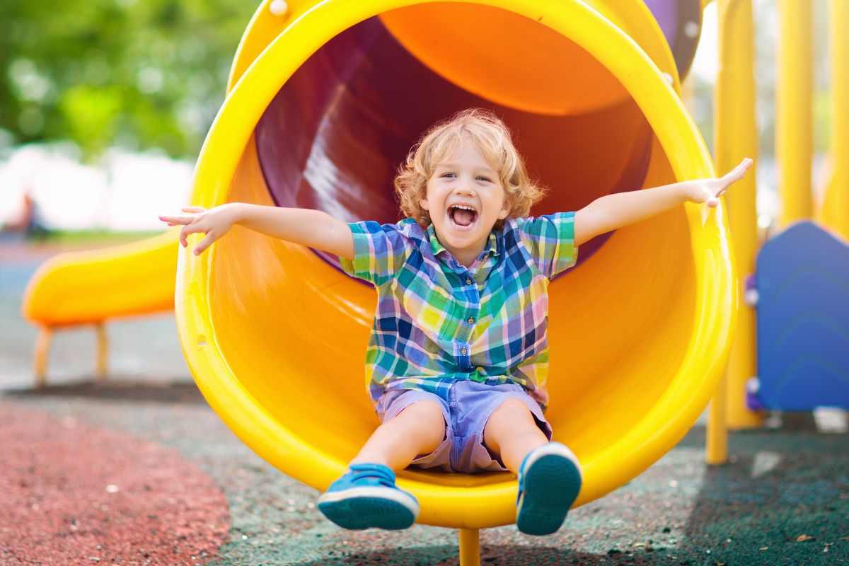 Bimbo gioca sullo scivolo