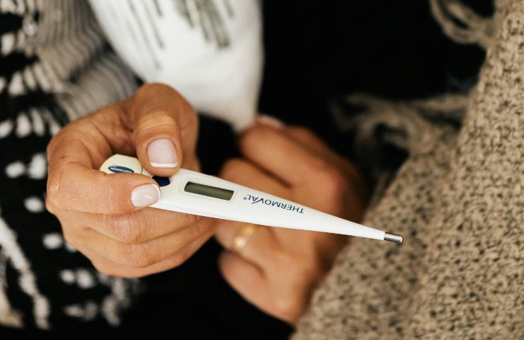 Termometro nella mano di una donna