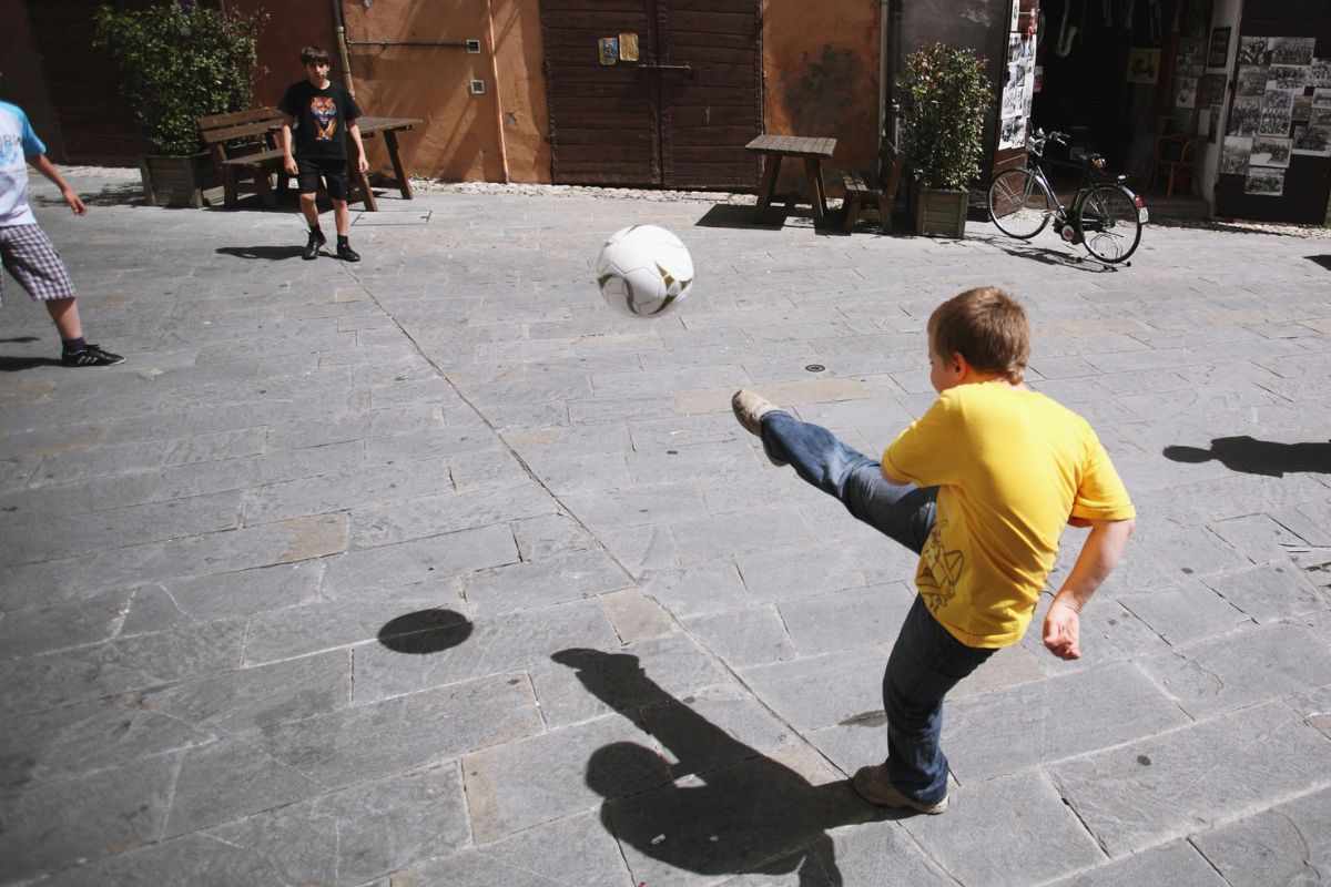 Bambini giocano a calcio in strada