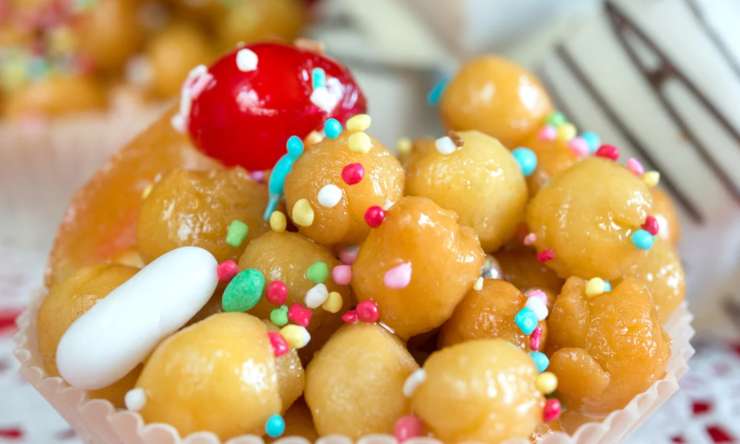 primo piano di struffoli con miele e confettini
