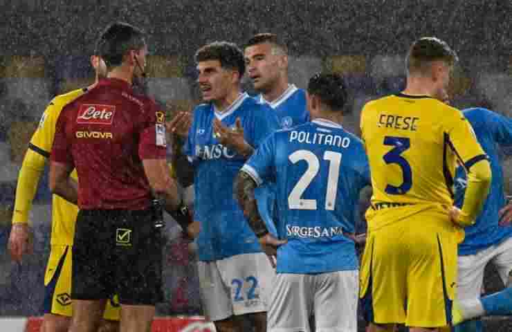 Giovanni Di Lorenzo parla con l'arbitro circondato da calciatori di Napoli e Verona