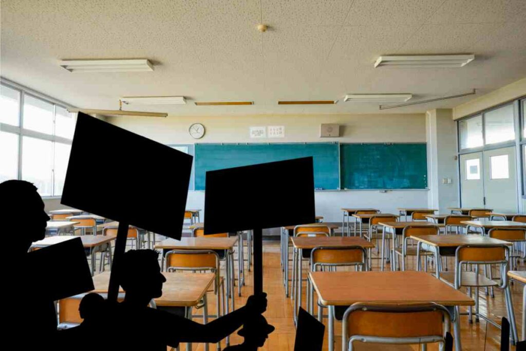 Aula scolastica vuota e sagome di scioperanti