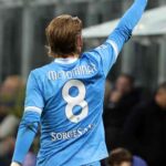 Scott McTominay di spalle col braccio alzato con la maglia del Napoli