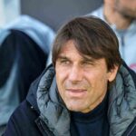 Antonio Conte con una giacca nera mentre guarda fuori obiettivo