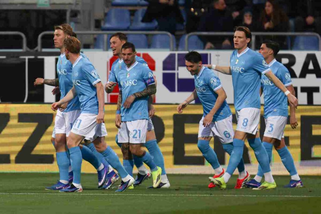 Calciatori del Napoli con maglia azzurra e pantaloncini bianchi tornano nella loro metà campo dopo avere segnato un gol.