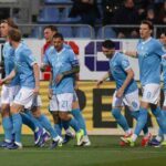 Calciatori del Napoli con maglia azzurra e pantaloncini bianchi tornano nella loro metà campo dopo avere segnato un gol.