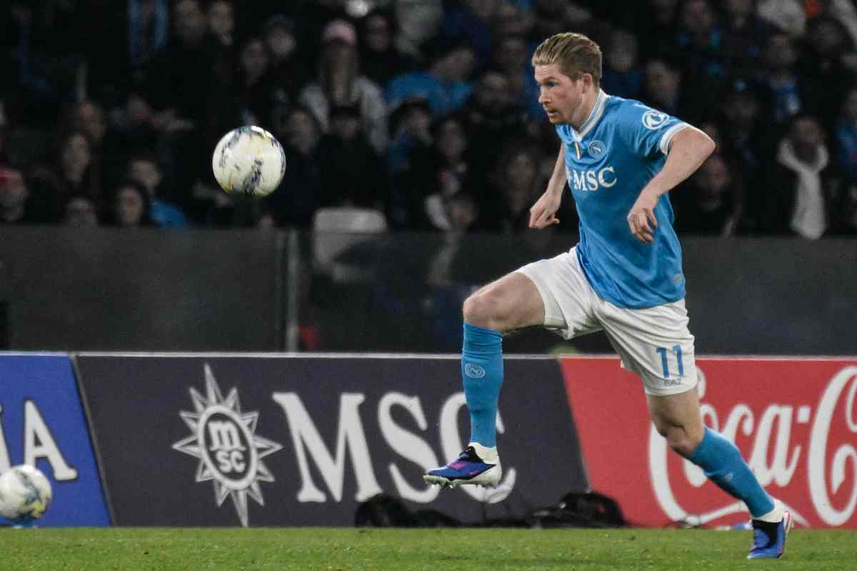 Kevin De Bruyne in progressione con indosso la tenuta di gioco azzurra e bianca del Napoli in campo mentre controlla il pallone.