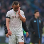 Stanislav Lobotka in tenuta da gioco bianca del Napoli si tocca il volto