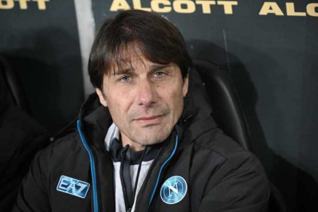 Primo piano di Antonio Conte con indosso il giubbotto ufficiale EA7 del Napoli, seduto in panchina con espressione concentrata prima della partita di Serie A contro il Torino.