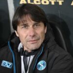 Primo piano di Antonio Conte con indosso il giubbotto ufficiale EA7 del Napoli, seduto in panchina con espressione concentrata prima della partita di Serie A contro il Torino.