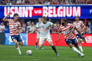 Kevin De Bruyne in azione col Belgio e contrastato da due avversari degli Stati Uniti.