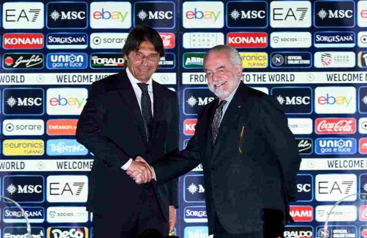 Antonio Conte ed Aurelio De Laurentiis che si stringono la mano davanti ad un pannello con gli sponsor.