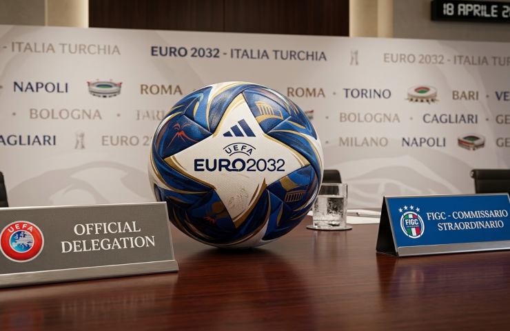 Incontro ufficiale UEFA e FIGC per il dossier Euro 2032 con il pallone del torneo in primo piano.