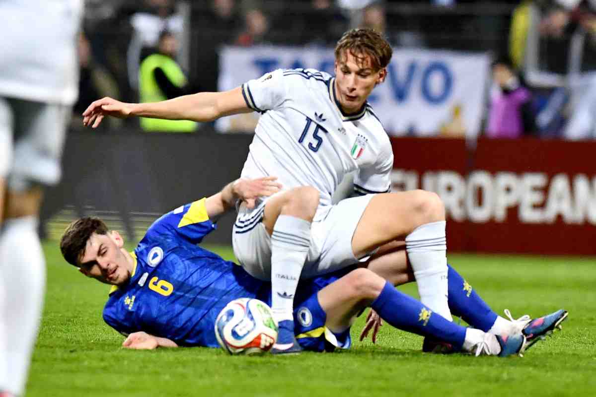 Pio Esposito contrastato da un avversario finisce a terra in Bosnia-Italia.