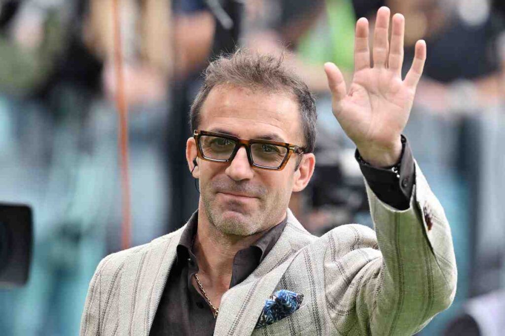 Alessandro Del Piero con occhiali fumè e giacca bianca saluta.