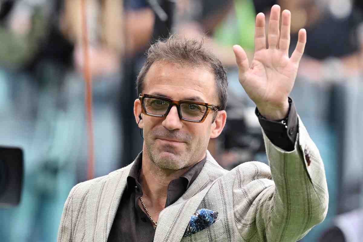 Alessandro Del Piero con occhiali fumè e giacca bianca saluta. 