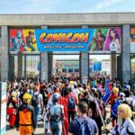 Ingresso Comicon Napoli 2026 alla Mostra d'Oltremare con folla di visitatori, cosplay e banner ufficiali dell'evento.