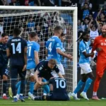 Calciatori del Napoli e della Lazio in campo durante un momento di gioco.