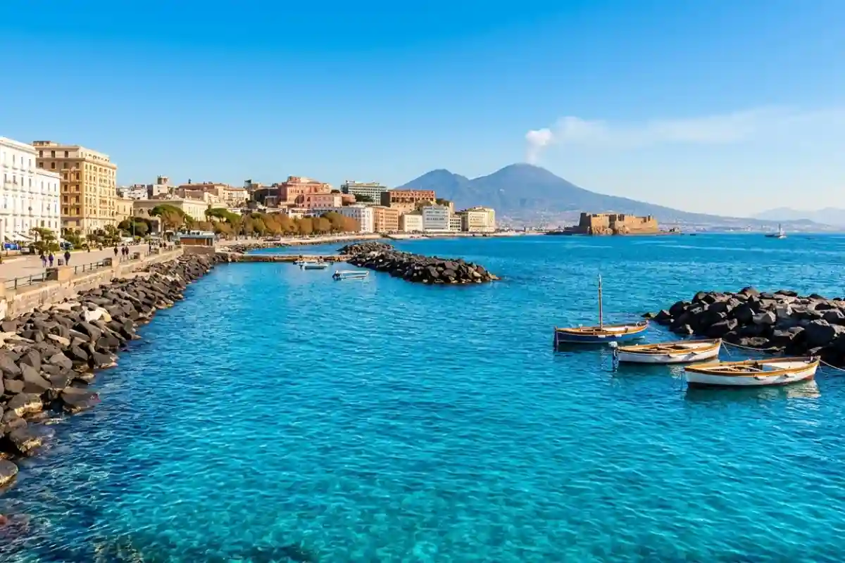 Lungomare Caracciolo Napoli con Castel dell'Ovo, Vesuvio e mare azzurro limpido.