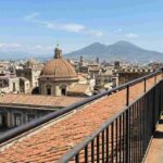 Passeggiata panoramica sui tetti del Duomo di Napoli con vista sul Vesuvio e centro storico durante il Maggio dei Monumenti 2026.