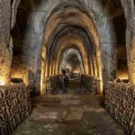 Interno del Cimitero delle Fontanelle a Napoli dopo la riapertura del 2026: navate in tufo, ossario restaurato e nuova illuminazione artistica nel Rione Sanità.