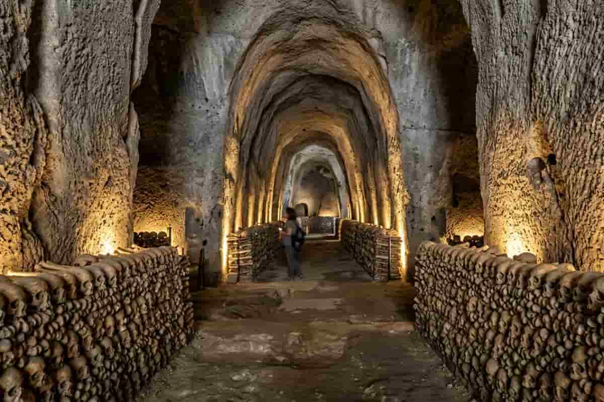 Interno del Cimitero delle Fontanelle a Napoli dopo la riapertura del 2026: navate in tufo, ossario restaurato e nuova illuminazione artistica nel Rione Sanità.