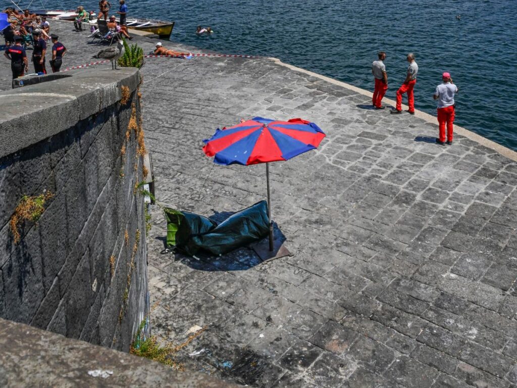 Cadavere conservato sotto un ombrellone dalle forze dell'ordine durante il sopralluogo sul lungomare di Napoli